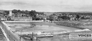 Houseboats moored on the river side of the old bridge.